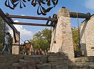 puits d'extraction de calcaire au bord desquelles se tiennent d'énormes pieds qui soutiennent les poulies