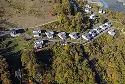 Petites maisons rectangulaires et grises.