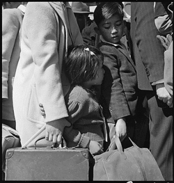 Byron en Californie. Troisième génération d'enfants américains d'ascendance japonaise en foule attendant l'arrivée du prochain bus qui les emmènera de chez eux au centre de regroupement (Assembly center). 2 mai 1942.