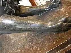 Partie d'une statue en bronze avec une inscription en alphabet étrusque.