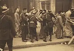 Policiers vietnamiens fouillant des civils chinois à un poste de contrôle.