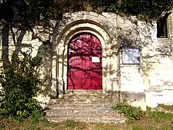 Photographie en couleurs d'un portail en bois peint en rouge.