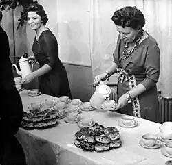 La reine Juliana et la princesse Beatrix servant des krentenbollen et du lait au chocolat pour leur équipe, le 22 décembre 1960 (photo : Harry Pot, Anefo).