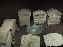 Vestiges du bouclier de bronze entre les urnes.