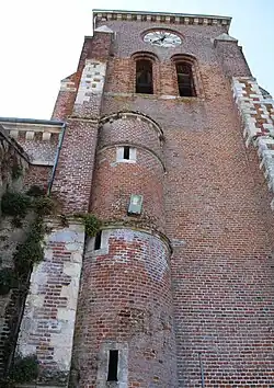 Une tour demi-cylindrique, percée de 3 meurtrières,  flanquant le clocher côté nord