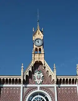 Gros plan sur le clocheton qui ornemente la façade du bâtiment voyageurs de la gare, par temps ensoleillé.