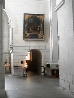 Photographie en couleurs d'un passage voûté dans un mur.