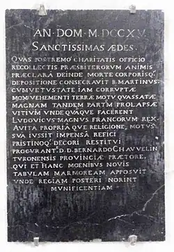 Photographie d'une plaque en ardoise portant un texte commémoratif.