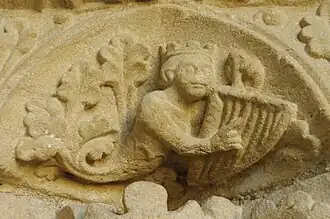 Photographie en couleurs d'une sculpture représentant un personnage couronné jouant de la lyre.