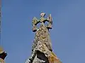 La croix antéfixe romane fixée sur le gable entre nef et chœur.