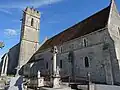 Les vestiges des arcades qui donnaient accès au bas-côté nord  sont visibles. La tour-clocher arbore deux gargouilles  sous son parapet crénelé.