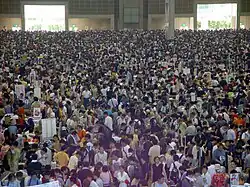 De nombreuses personnes sont réuniens dans un très grand hall.