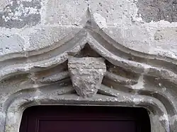 Détail linteau en accolade avec un blason au chef de l'Ordre.