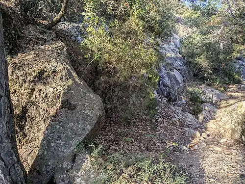 Affleurements de conglomérat paléocène (à gauche) et de granite hercynien (à droite), situés juste au nord du village de Coustouges, à travers laquelle passe la limite du flanc sud de la zone axiale des Pyrénées.