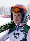 portrait tête et épaules de Urša Bogataj avec son casque et ses skis sur son épaule droite