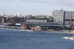 Photographie d'une zone portuaire urbaine ; au premier plan, un entrepôt marqué du logo de l'UNICEF.
