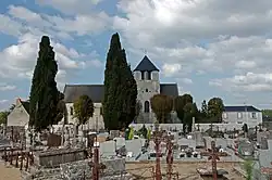 Photographie en couleurs d'une église en arrière-plan d'un cimetière.
