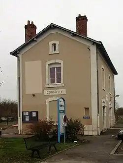 Photographie en couleurs d'une maison longée par une voie ferrée.