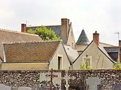 Photographie en couleurs de deux toits, dont celui d'une tour ronde, émergeant d'autres toits environnants.