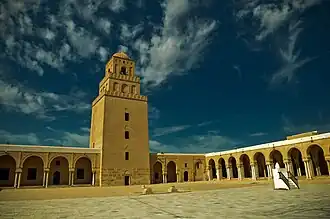Vue de la cour et du minaret à trois étages dégressifs superposés.