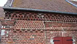 Agencement de briques sur le mur de la mairie.
