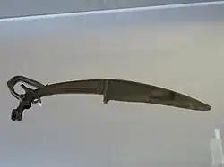 Couteau xiao à tête de bouquetin ibex. Nord ou Nord-Ouest de la Chine trouvé au Shanxi. Bronze. XIIIe – XIe&nbsp;siècle&nbsp;av. J.-C.. Musée Cernuschi