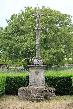 Croix de Ténuel en France composée d'un soubassement évidé d'une niche, un socle à sommet hémisphérique et une croix séparée du fût écoté par un nœud-boule.