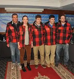 5&nbsp;personnes dont une femme en veste de ski à carreaux rouges et noirs, pantalon de ville