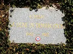 Une plaque commémorative sur un mur avec le légende « Ici passait la ligne de démarcation 1940-1943 »