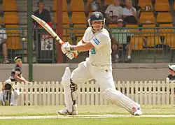 Photographie représentant David Warner en train de batter, prise en 2011.