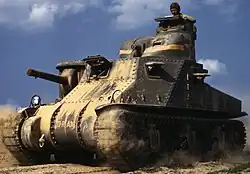 photographie en couleur montrant un char roulant dans le sable