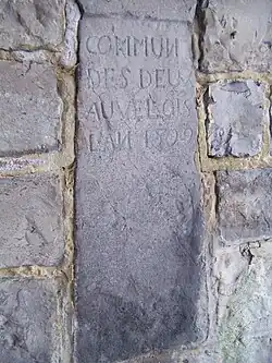 Pierre sculptée contenant l'inscription "Commune des deux Auvelois, l'an 1802" située près de la piscine d'Auvelais.
