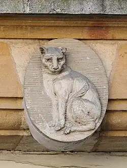 Sculpture d'un chat dans un médaillon au-dessus du passage, à gauche. Animal figurant dans les armes de Jean Vivant Micault de Corbeton