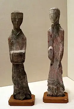 Photographie montrant deux figurines en bois représentant deux personnes.