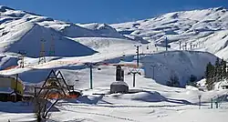 Domaine de ski enneigé avec des remontées mécaniques.