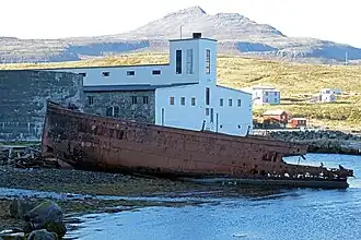 Friche portuaire à Djúpavík dominée par la Búrfell.