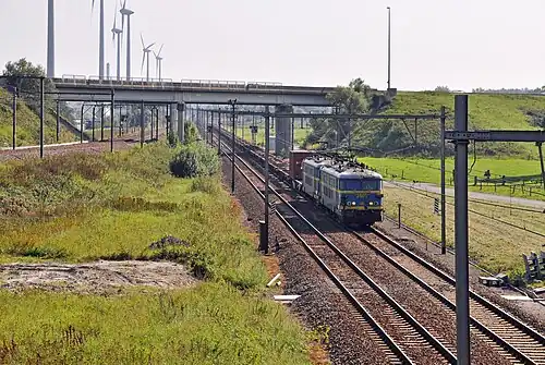 La jonction "Y Dudzele". À gauche: la ligne 51B de Knokke. À droite et à l'avant-plan: la ligne 51A venant de Zeebruges-Plage. La photo est prise en direction de Bruges. Le train de fret, tracté par deux locomotives de la série 26, roule en direction de Zeebruges.
