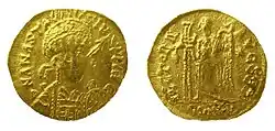 Photo des deux faces d'une pièce d'or, avec le portrait d'un homme de face à l'avers et une silhouette ailée au revers.