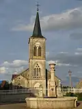 L'église Saint-Étienne avec la fontaine ronde au premier plan