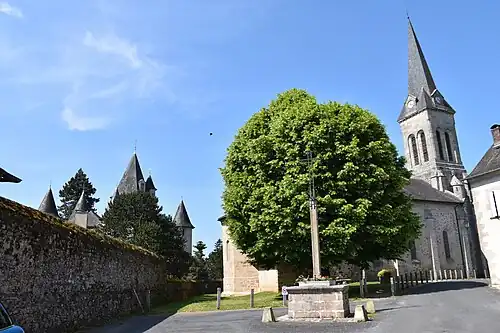 Vue latérale de l'église, à gauche les tours du château, au premier plan, le tilleul planté én 1831.