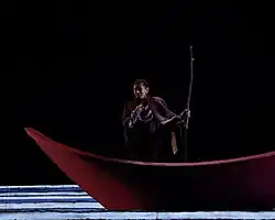 Une femme en costume chante l'opéra sur scène.