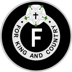 Emblème avec au milieu la lettre F entourée des mots « FOR KING AND COUNTRY » avec au-dessus une rose blanche et une croix de Jésus.