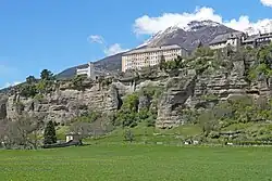 Photo montrant une petite falaise haute de quelques dizaines de mètres couronnée d'habitations.