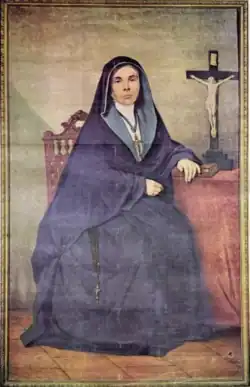 portrait d'une religieuse assise, à côté d'un crucifix