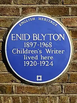 Plaque commémorative à fond bleu, de forme ronde.