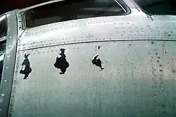 Photographie couleur du fuselage de l'avion avec des marques d'usures.