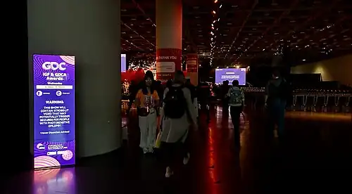 Le public prend place dans le fond de la salle, derrière les nommés...