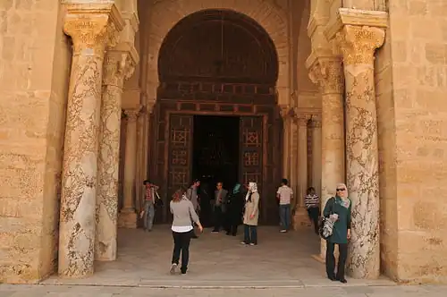 Fûts de colonnes en marbre blanc veiné encadrant l'entrée principale de la salle de prière de la grande mosquée de Kairouan.