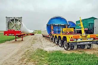 Segments du mât sur remorques et embase d'une pale.