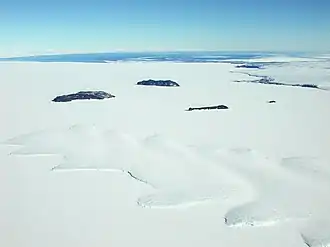 Vue aérienne des îles Dellbridge avec de gauche à droite l'île Tent, l'île Inaccessible, l'île Big Razorback et l'île Little Razorback et au premier plan l'extrémité du glacier Erebus.